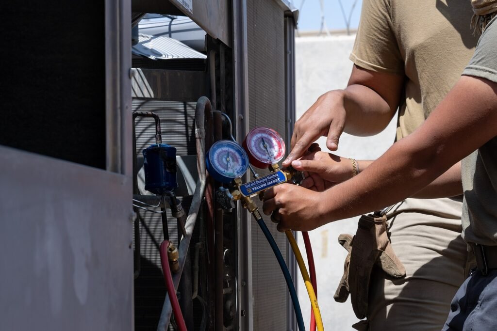 A service technician working on an air conditioning unit