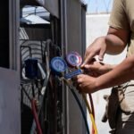 A service technician working on an air conditioning unit