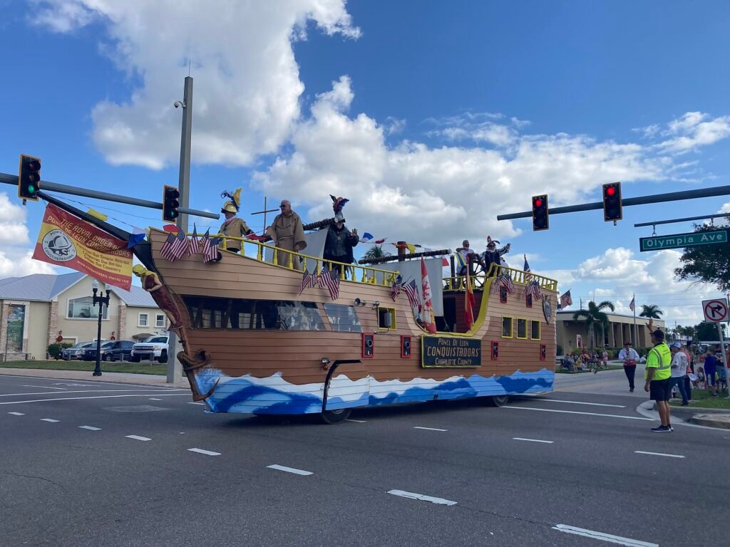 A wooden pirate-ship parade float rolling through downtown Punta Gorda
